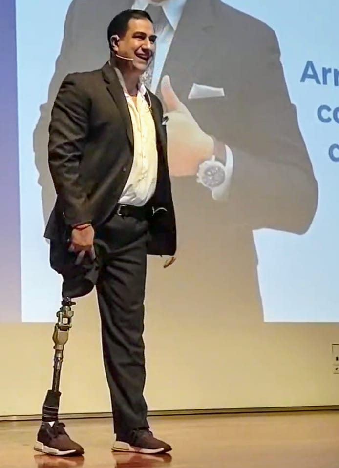 Rafael Domínguez en escenario mostrando su prótesis